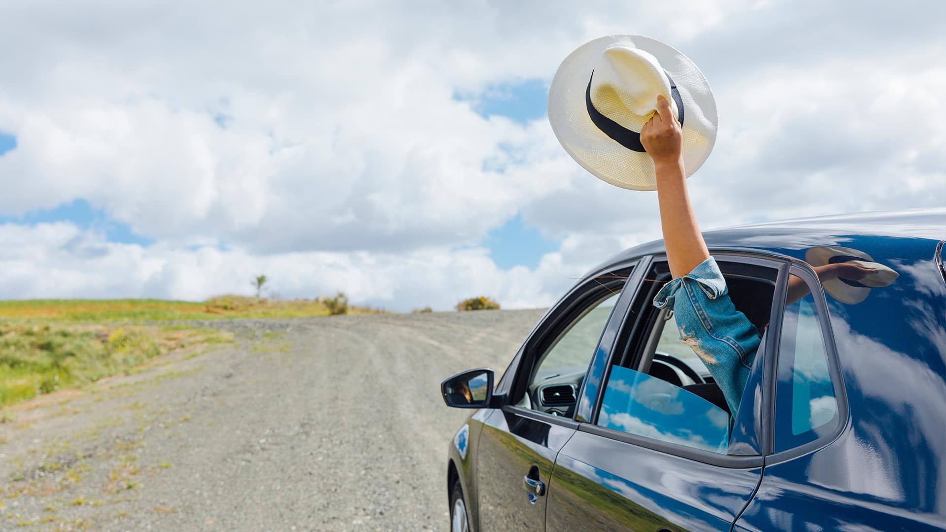 Car on a scenic summer road trip, showcasing well-maintained features with AlloyGator and Rimblades.